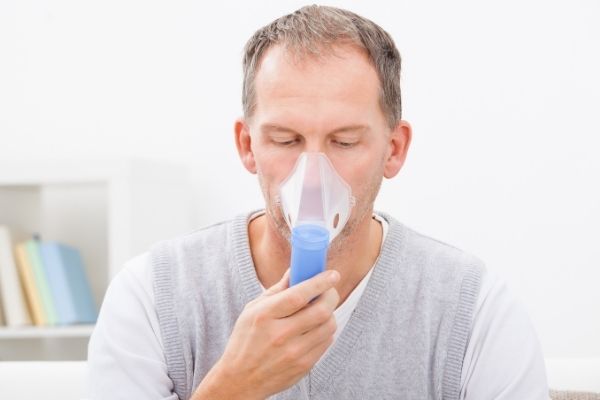 man using breathing device