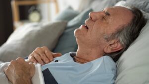 A veteran diagnosed with sleep apnea sleeps with his mouth open. Under the proposed VA sleep apnea rating changes, he may no longer qualify for benefits.