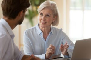 An older woman speaks with a lawyer and asks, “How can an elder law attorney help me?”