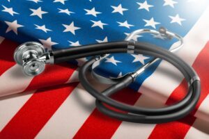 Stethoscope on an American flag, with someone nearby interested in learning more about VA priority groups for healthcare
