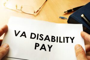 A piece of paper with “VA Disability Pay” written on it, with someone nearby interested in learning about the VA disability 5-year rule